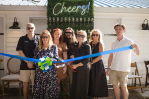 a group of people standing next to each other holding a blue ribbon