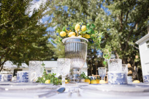 a table set for a formal dinner with lemons in a vase