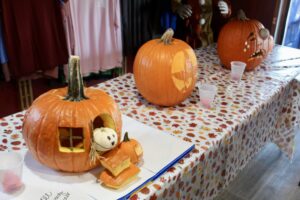 a table topped with pumpkins and a stuffed animal