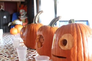 a table topped with pumpkins with faces painted on them