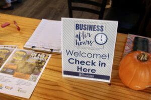 a wooden table topped with a sign and a pumpkin