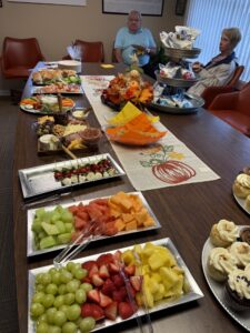 a group of people sitting at a table with trays of food
