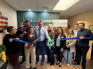 a group of people holding a ribbon in a room