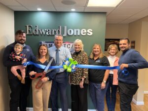 a group of people holding a blue ribbon in front of a wall