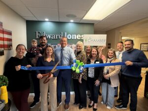 a group of people holding a blue ribbon in front of a wall