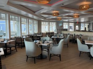 a restaurant with tables, chairs, and windows