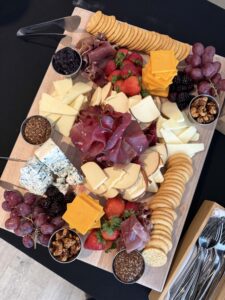 a platter of cheese, crackers, fruit and nuts