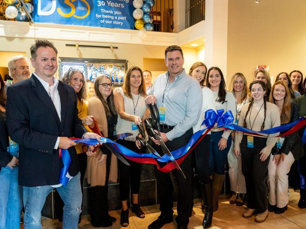 a group of people standing around a ribbon cutting ceremony