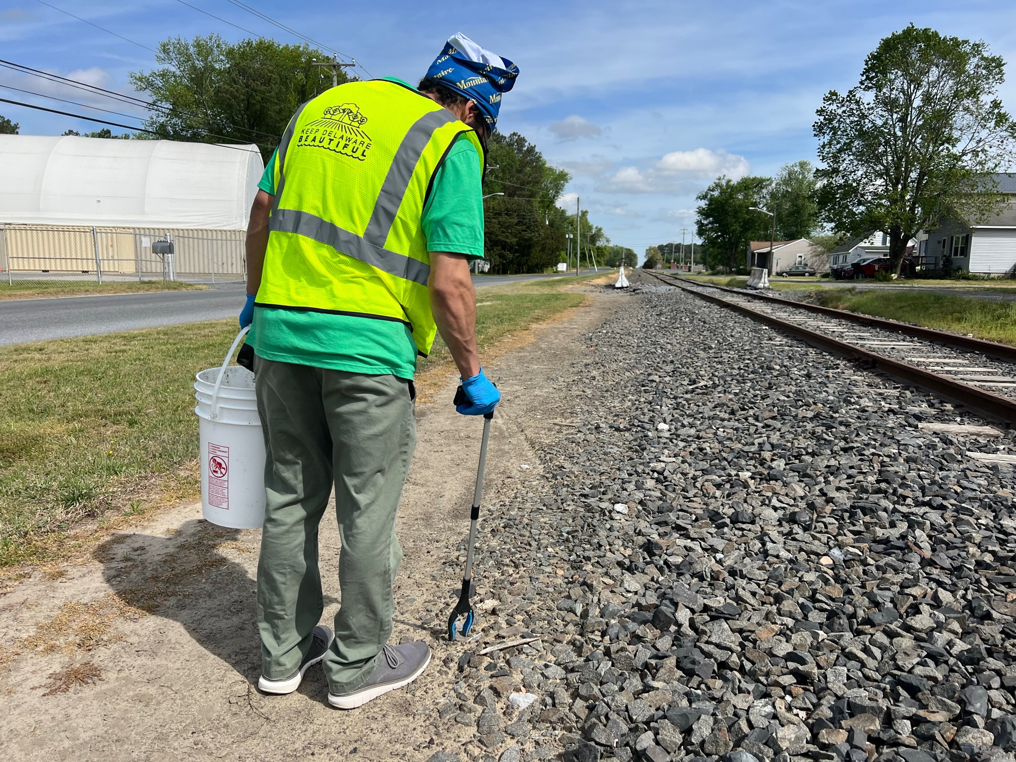 a man in a safety vest is walking along a railroad track