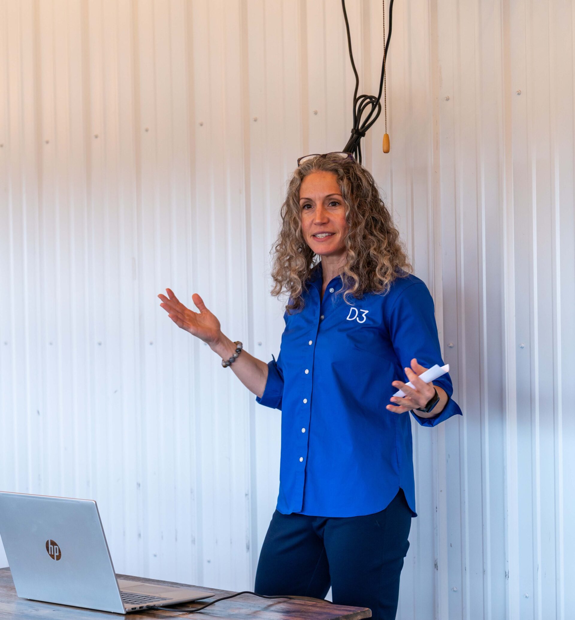 a woman standing in front of a laptop computer