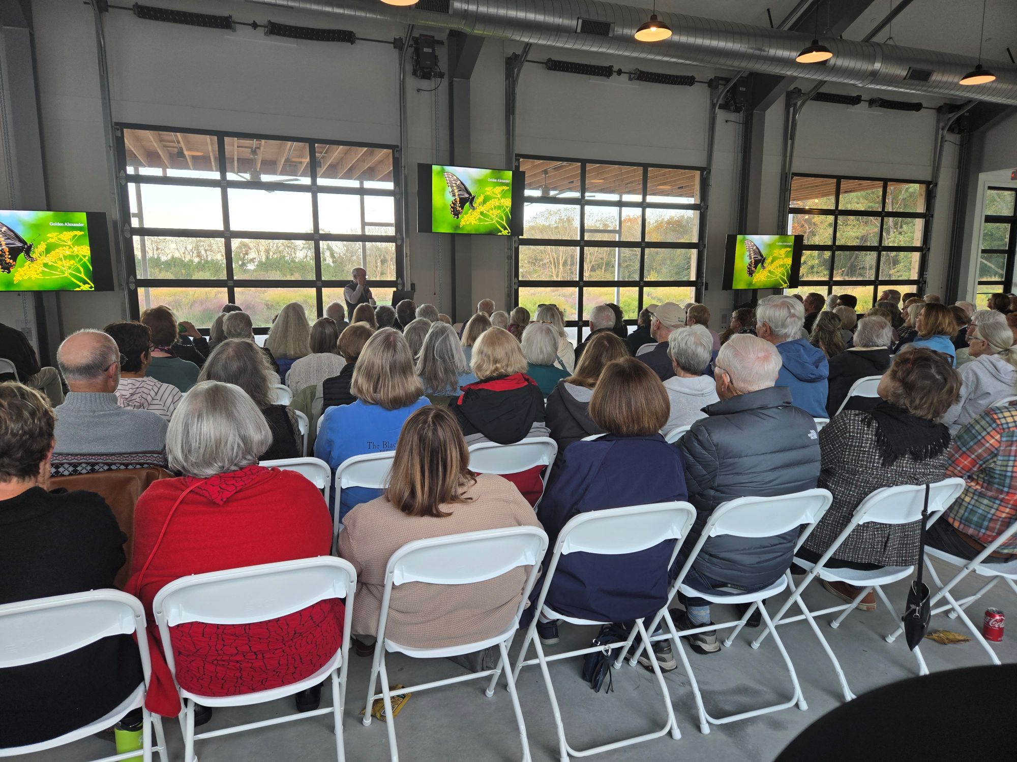 a group of people sitting in a room watching televisions