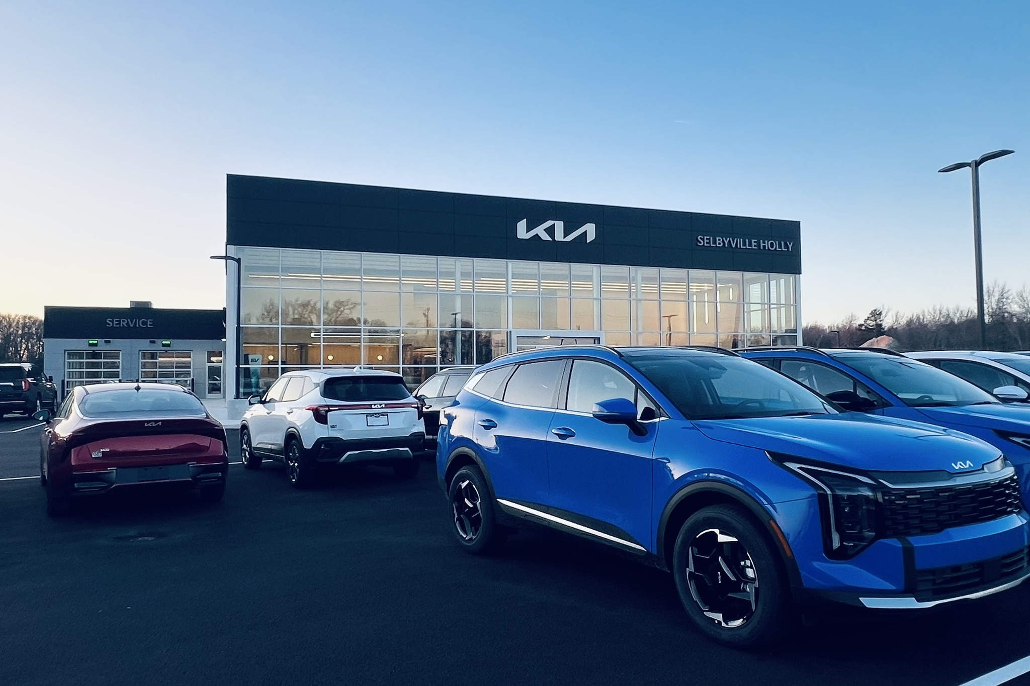 a row of cars parked in front of a dealership