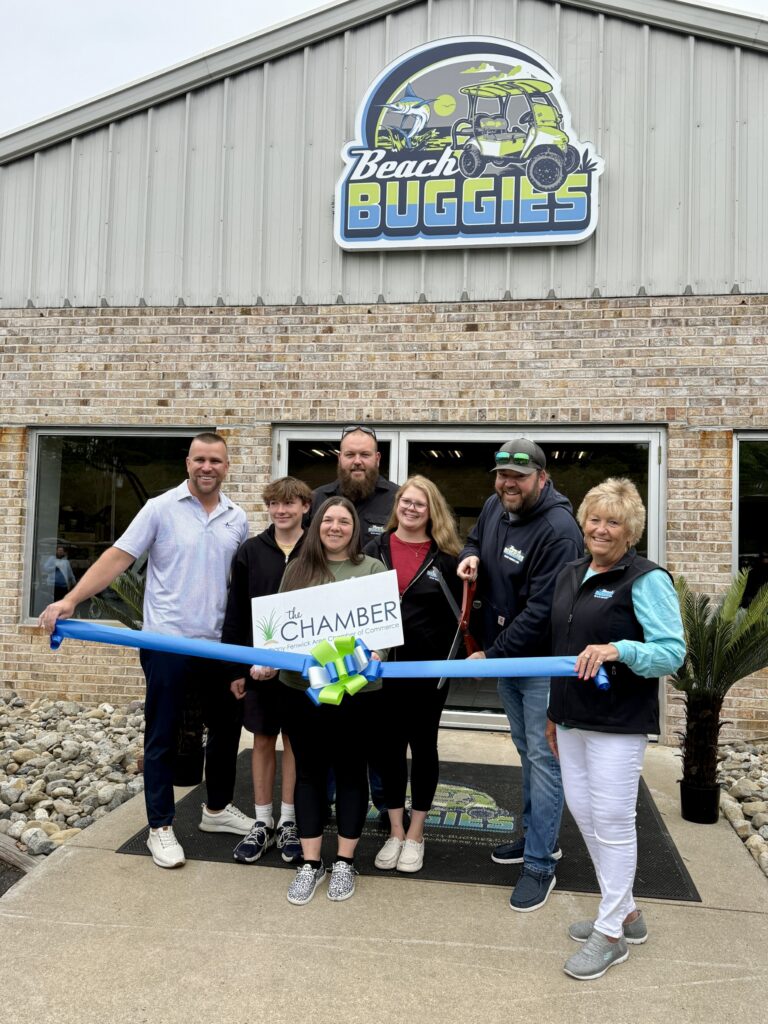 a group of people holding a ribbon in front of a building