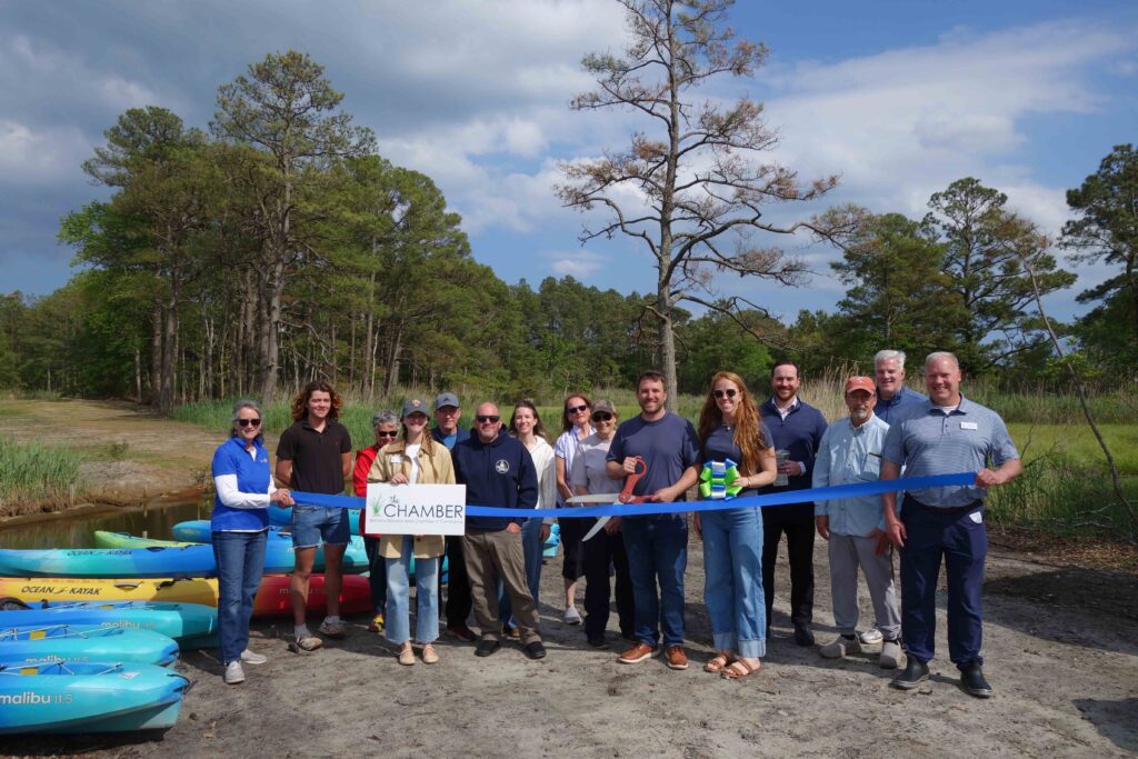 a group of people standing next to each other holding a ribbon