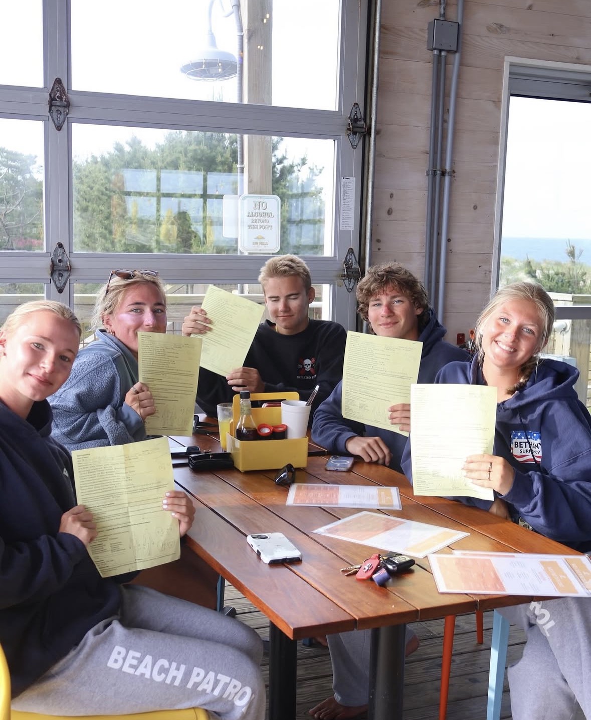 a group of people sitting around a wooden table