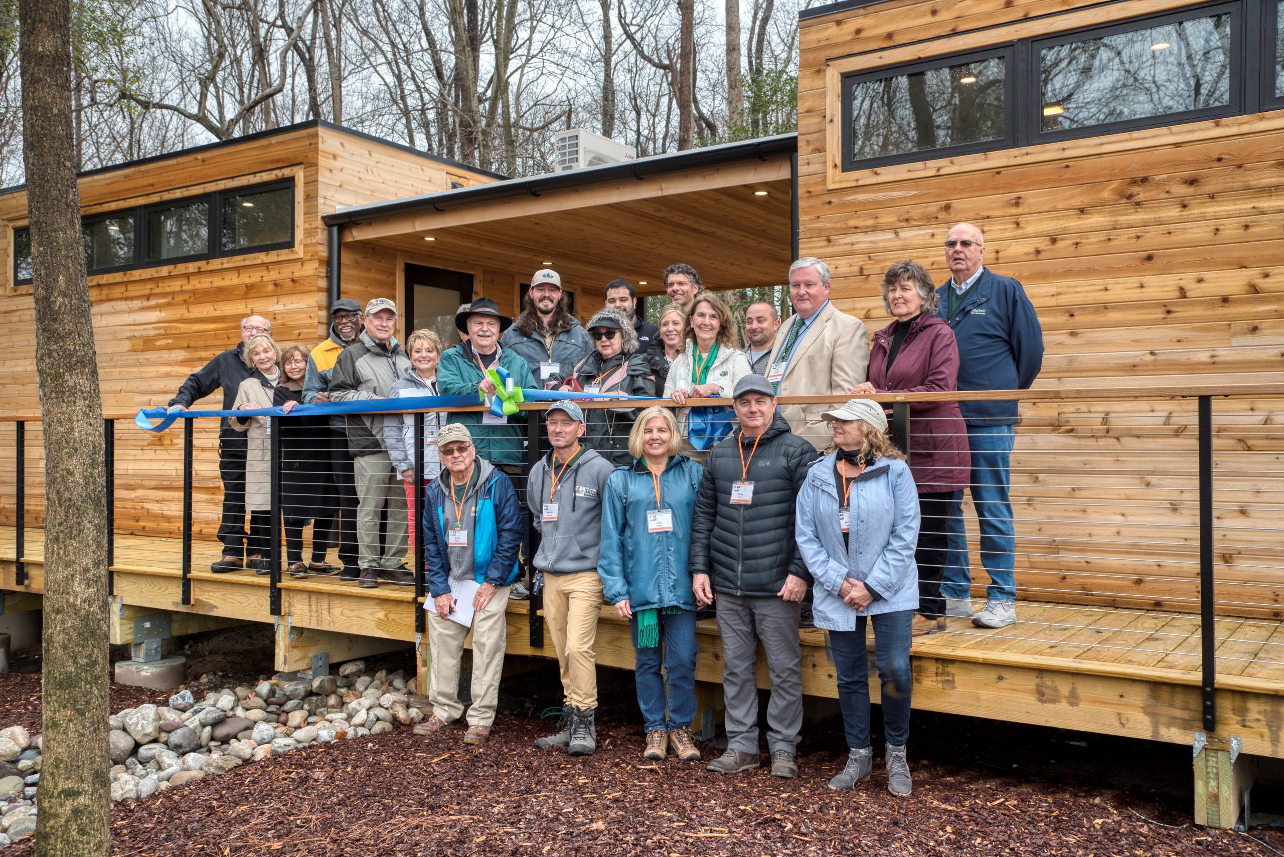 a group of people standing outside of a wooden cabin