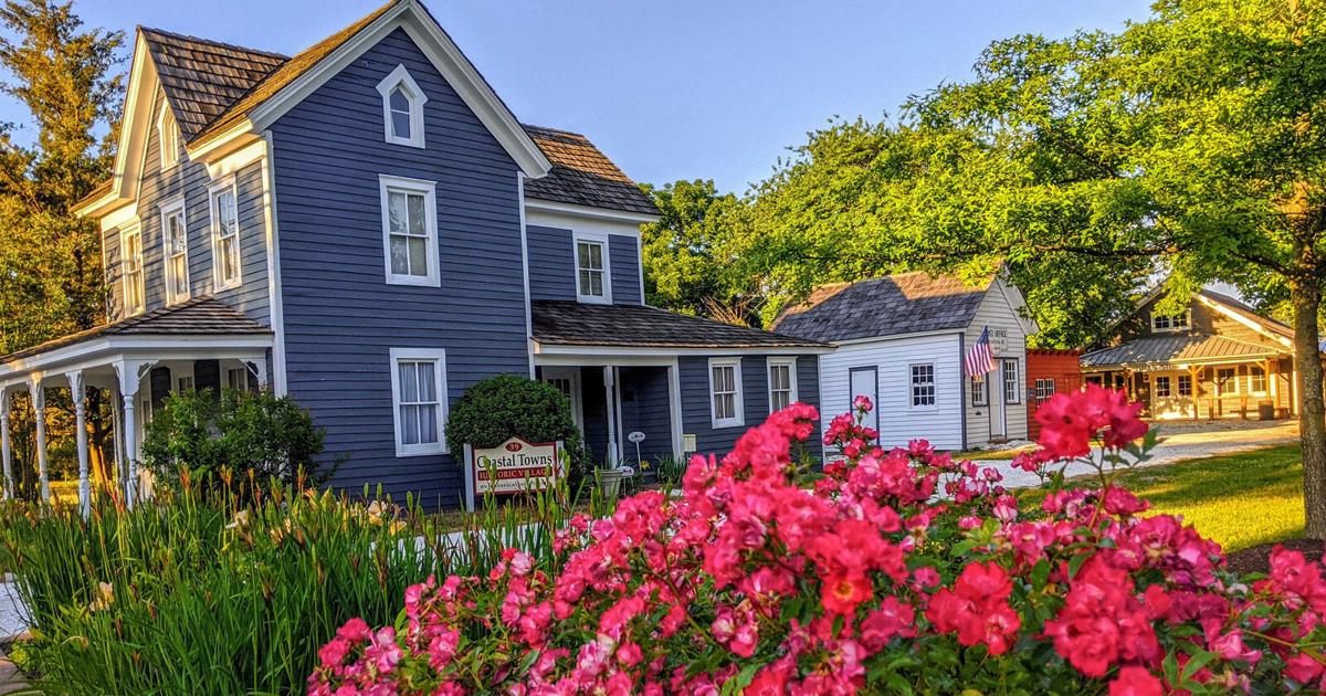 a blue house with pink flowers in front of it
