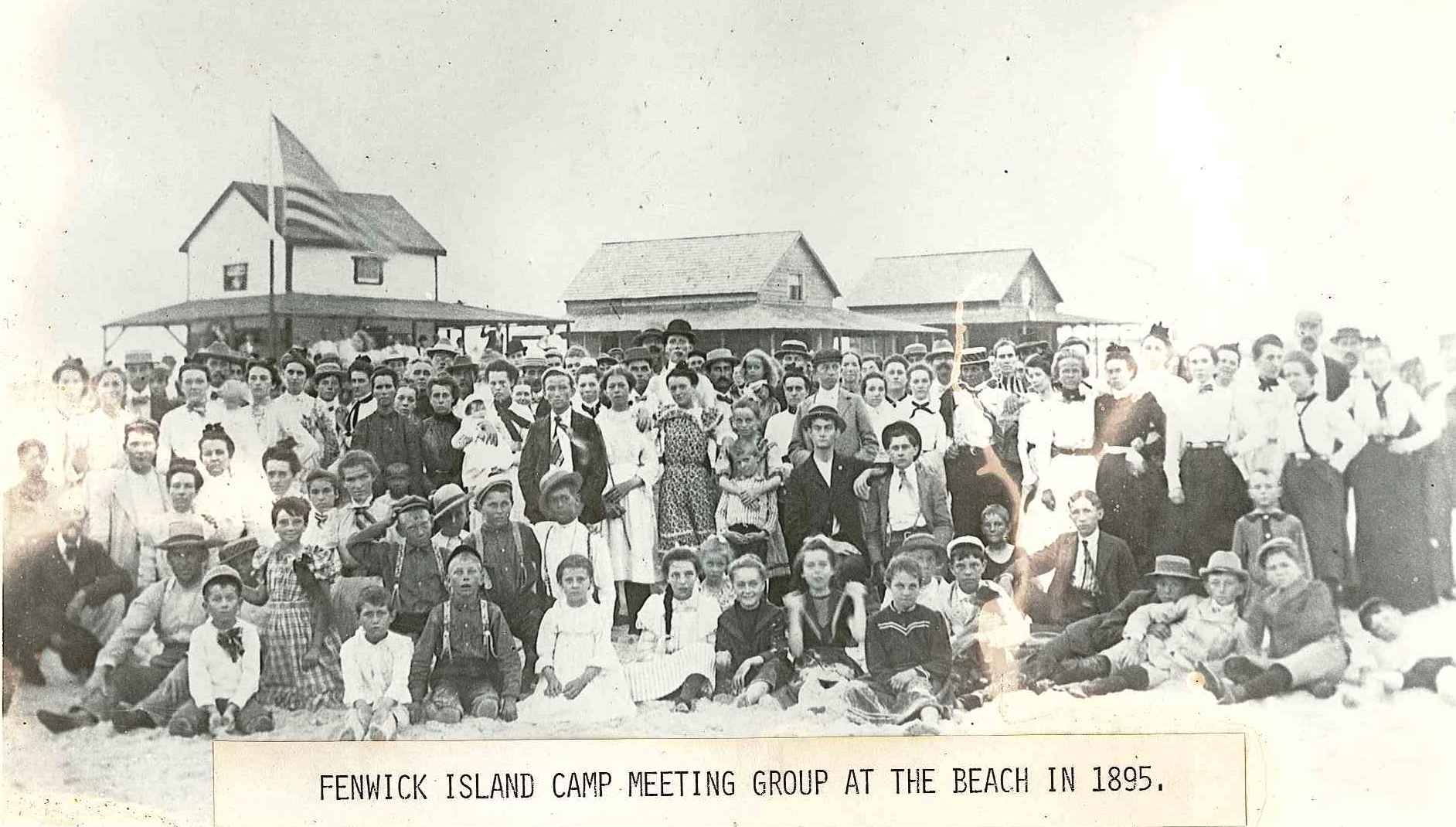 a group of people standing and sitting in front of a building
