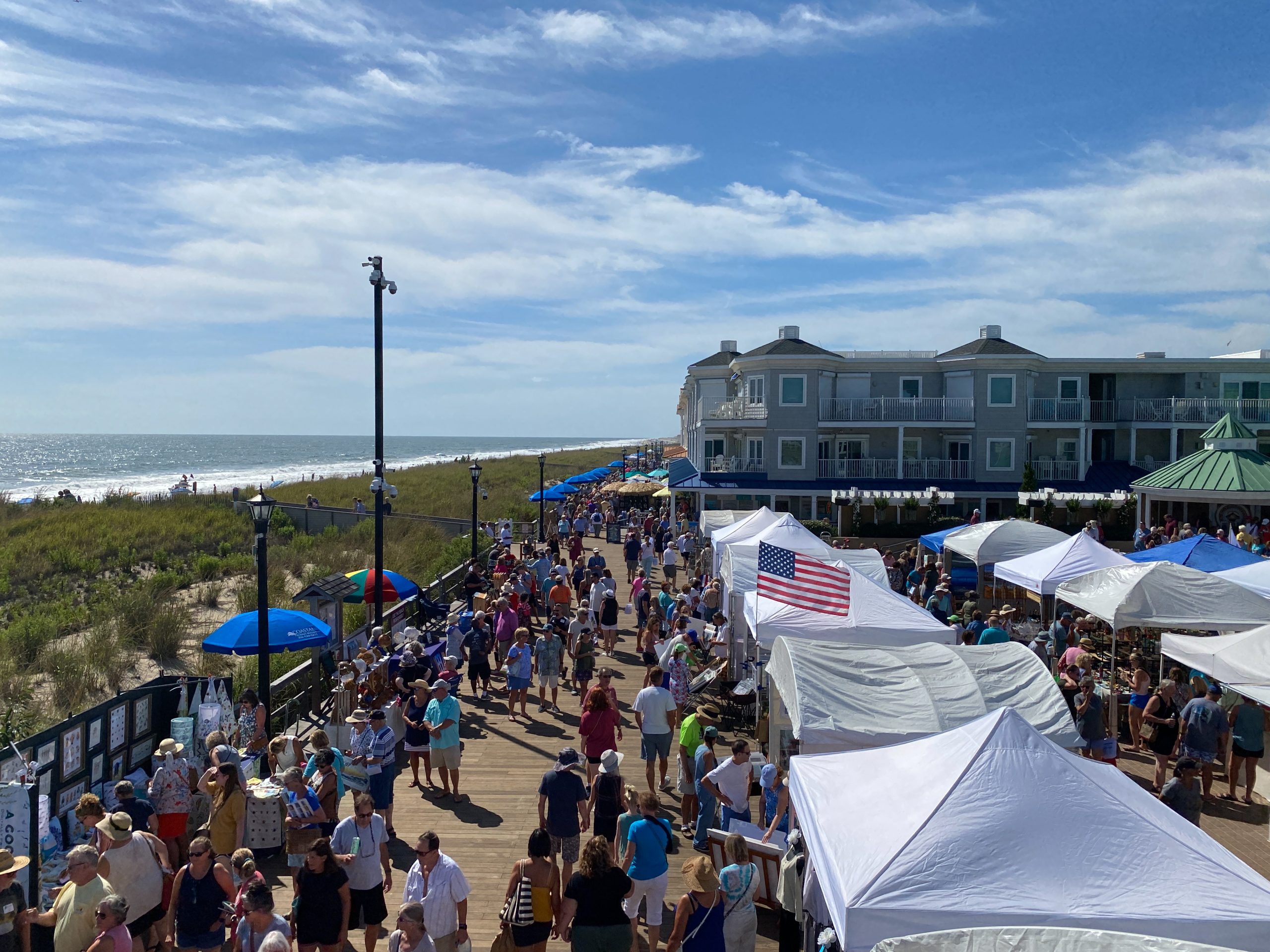 a crowd of people standing on top of a sandy beach