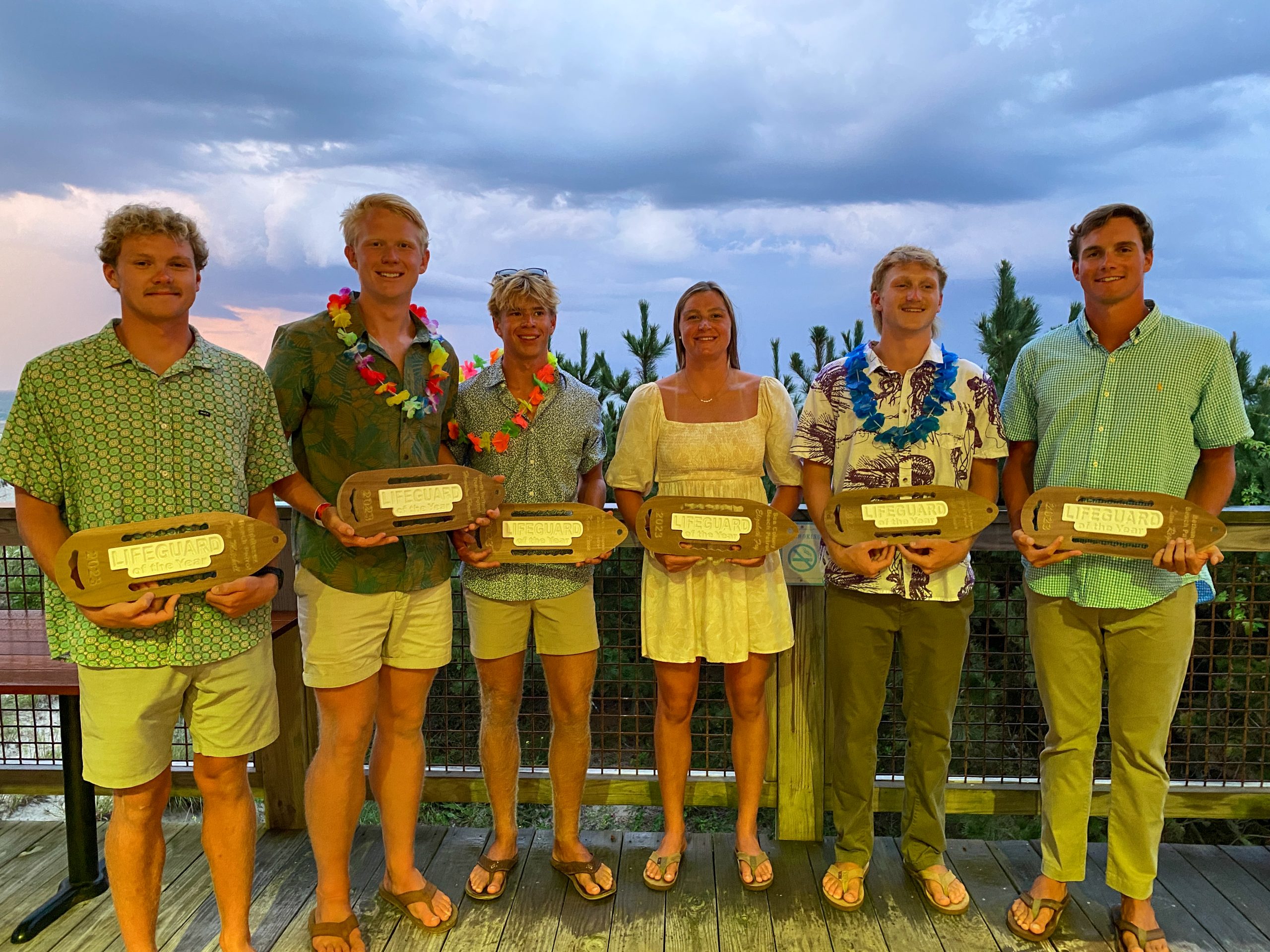 a group of people standing next to each other holding plaques