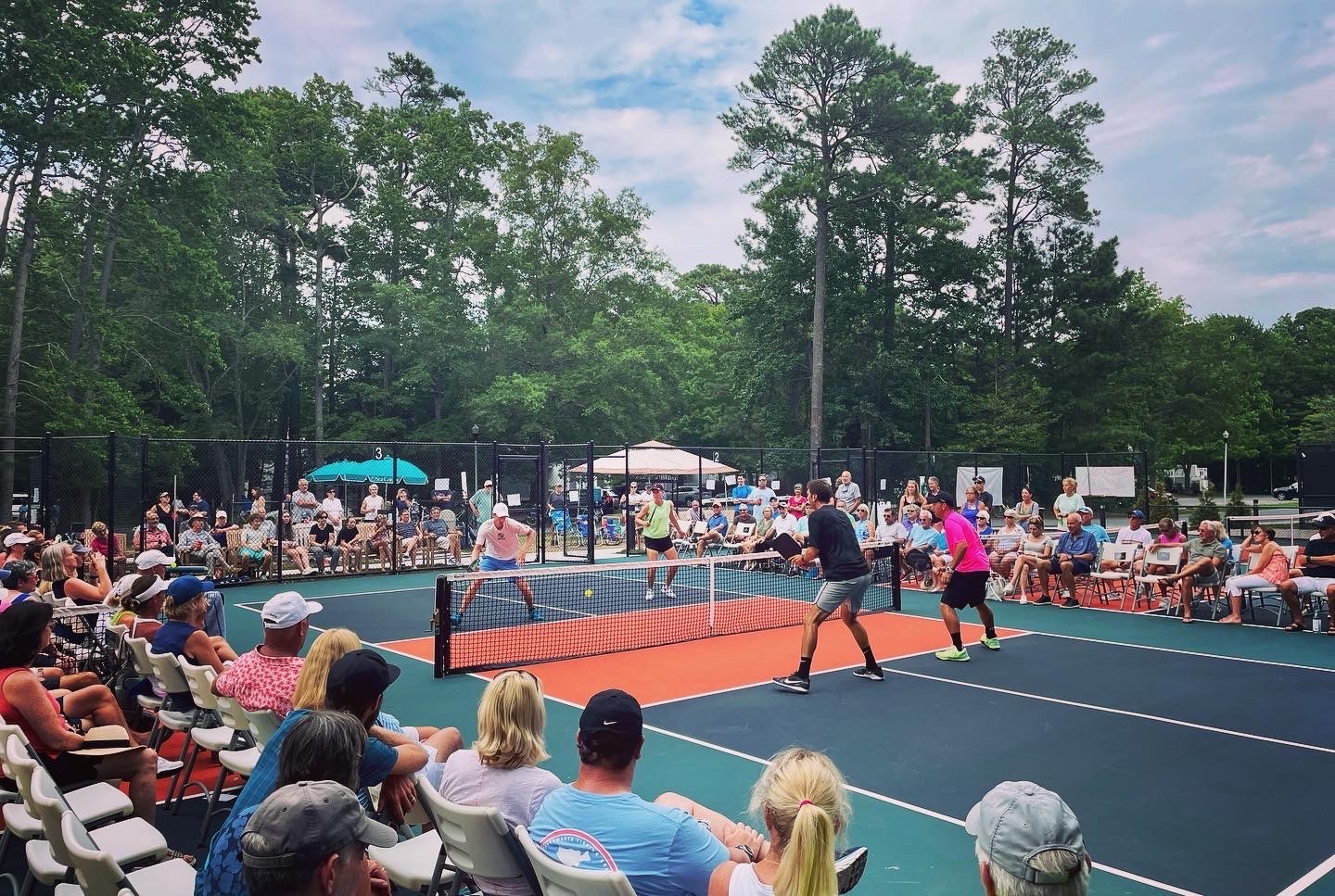 two people playing tennis on a blue and green court