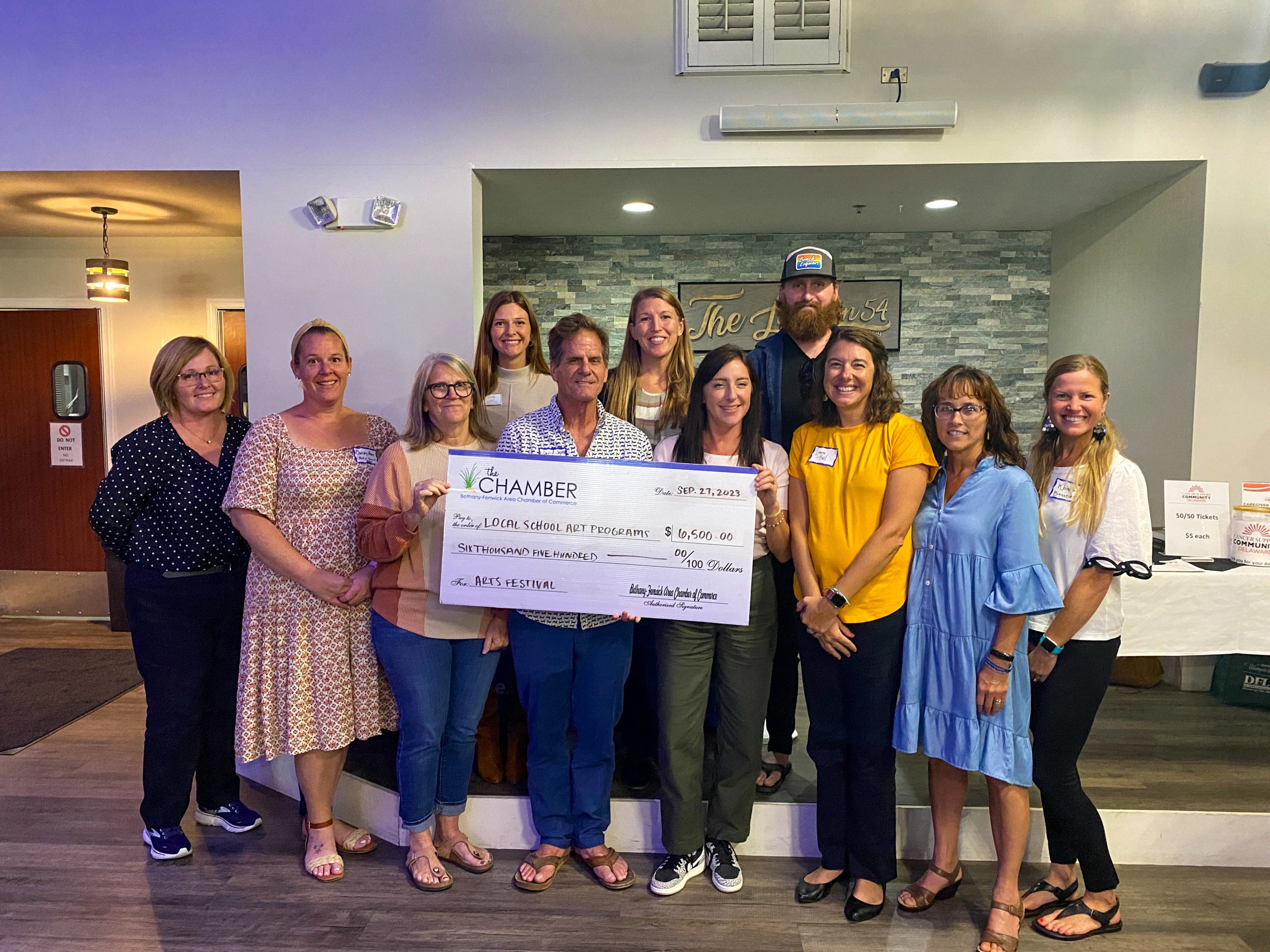 a group of people holding a large check