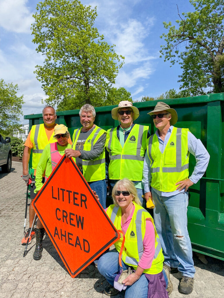 a group of people standing next to each other near a dumpster
