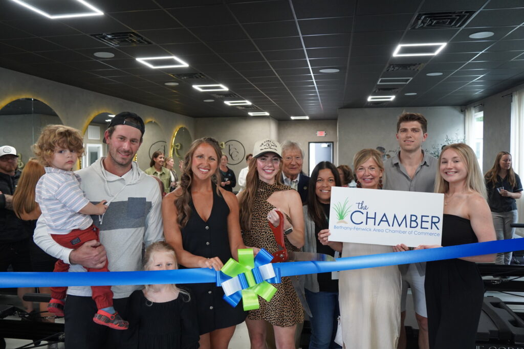 a group of people standing around a ribbon cutting a ribbon