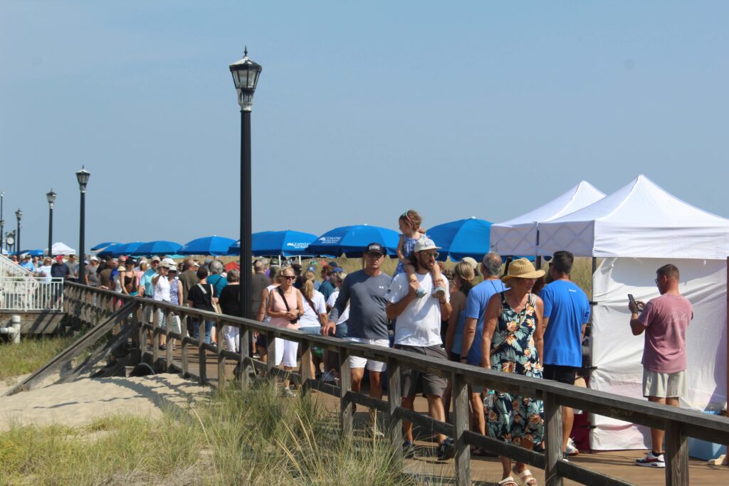 a crowd of people standing on top of a pier