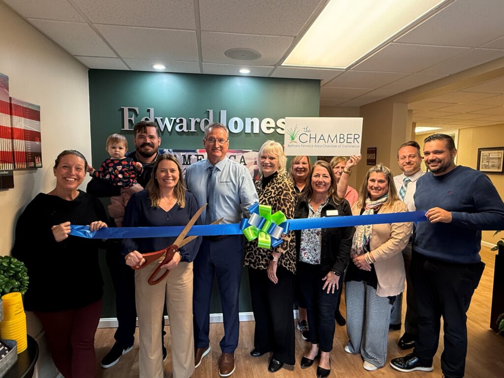a group of people holding a blue ribbon in front of a wall