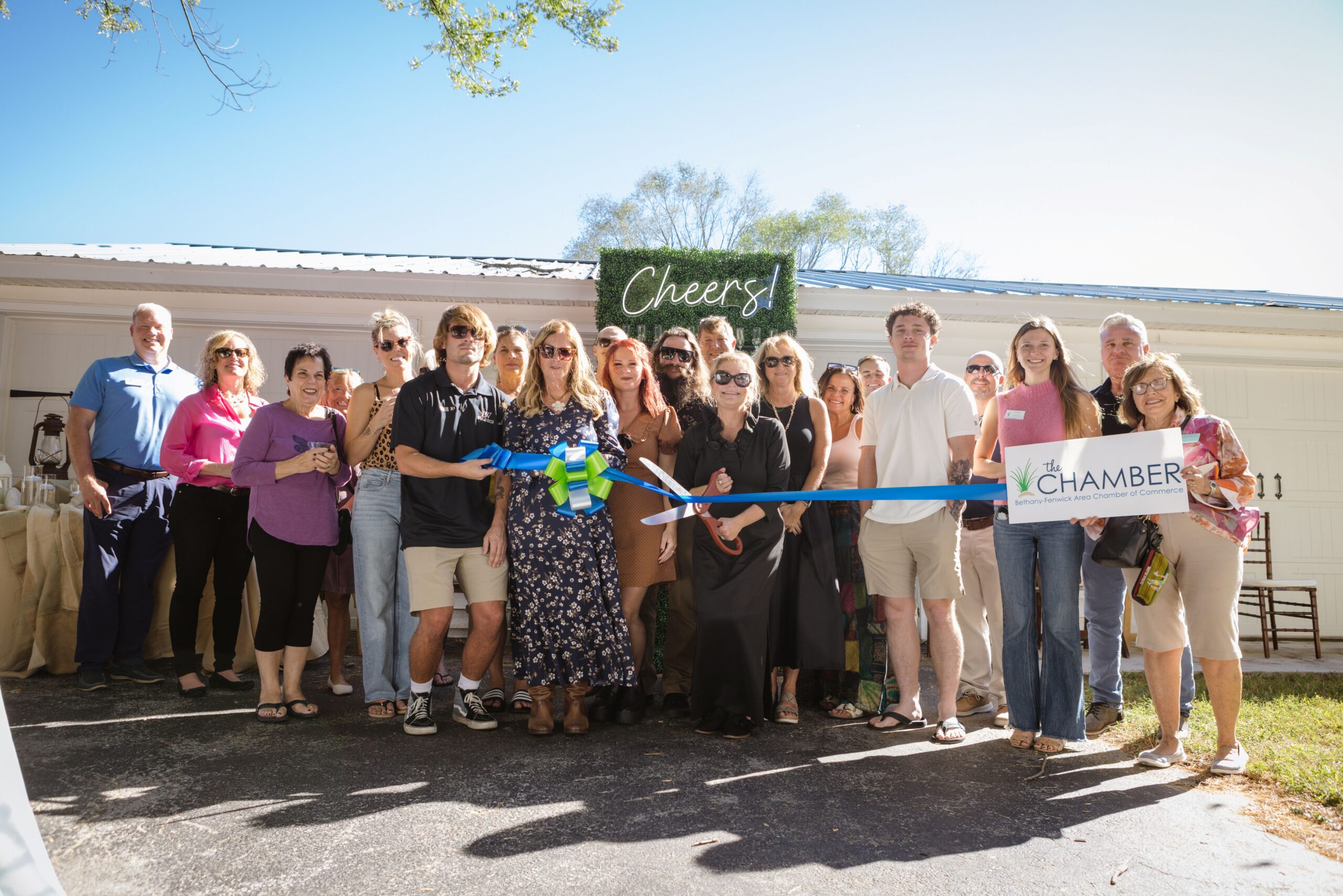 a group of people holding a ribbon in front of a building