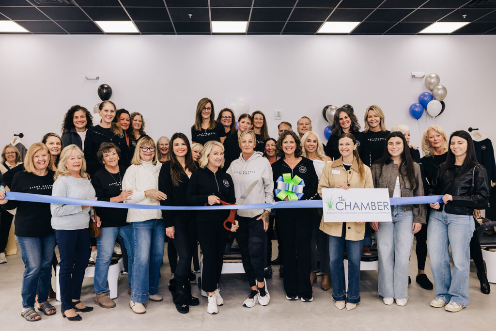 a group of women standing in front of a ribbon