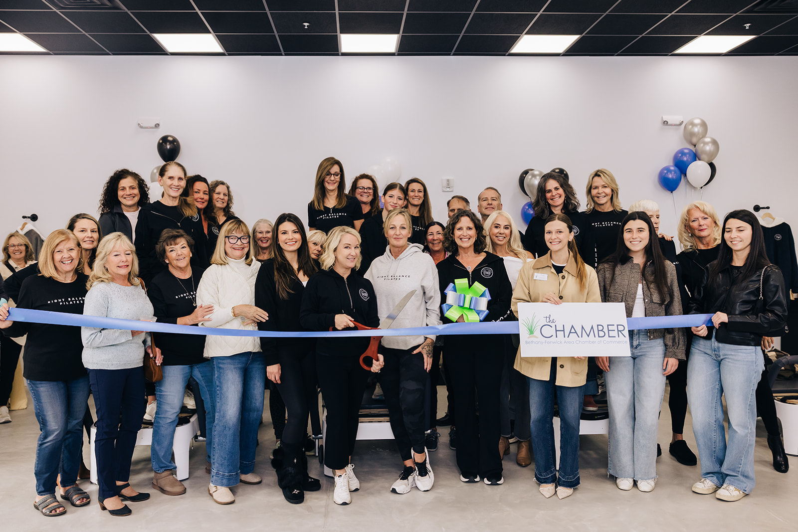 a group of women standing in front of a ribbon