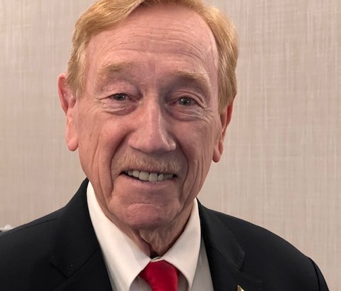 a man in a suit and tie smiling for the camera