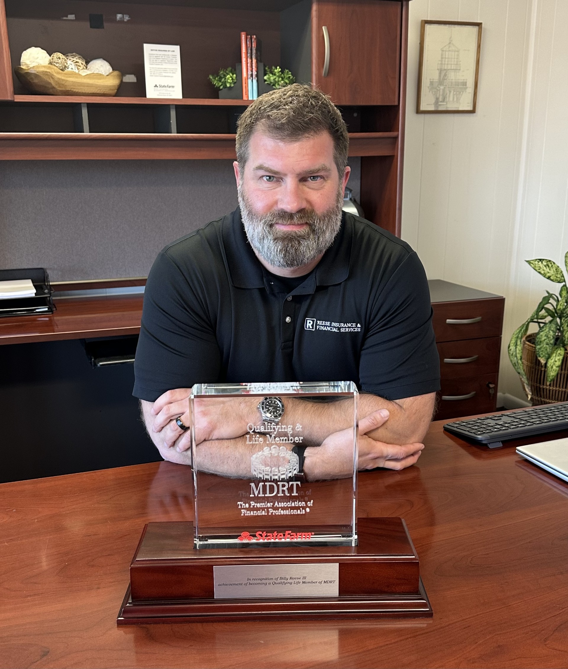 a man sitting at a desk with a plaque