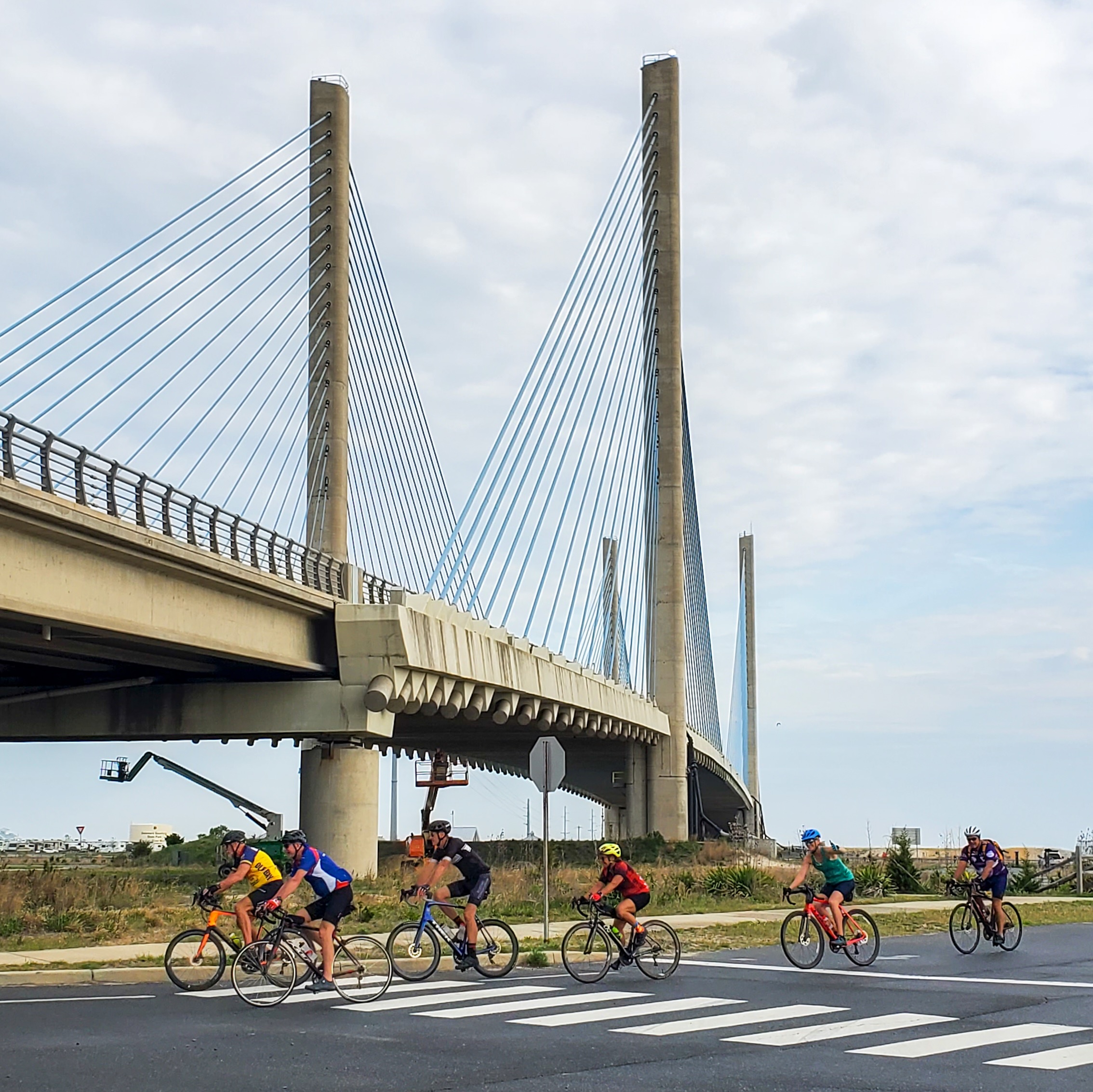 a group of people riding bikes across a bridge