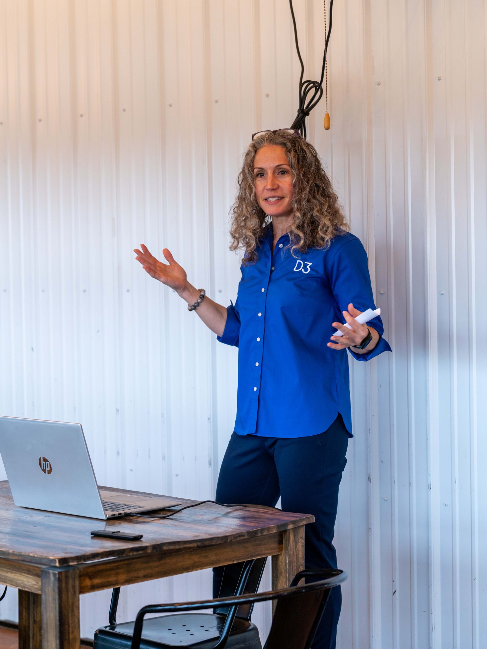 a woman standing in front of a laptop computer