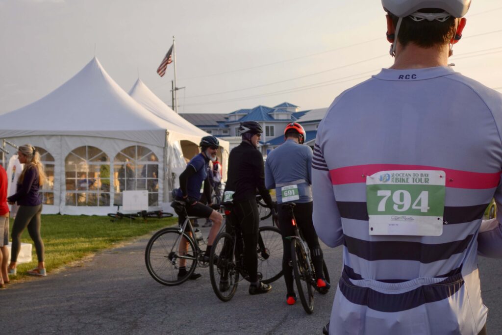 a group of bicyclists standing around a tent