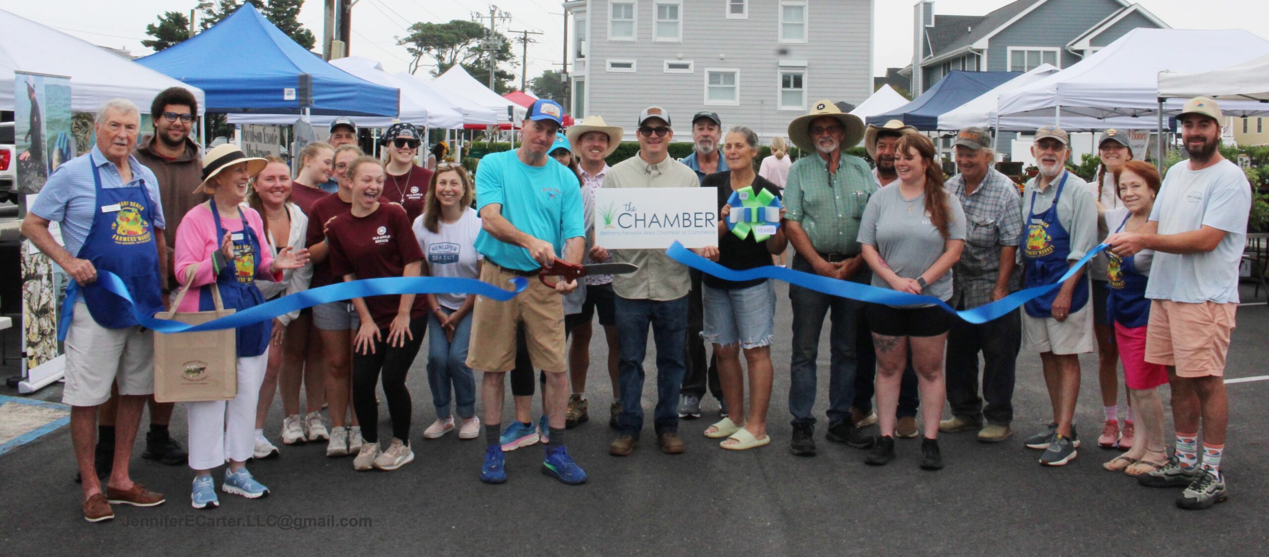 a group of people standing around a blue ribbon