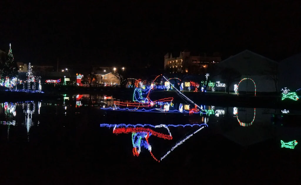 a lake filled with christmas lights at night
