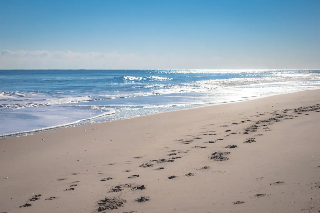 a sandy beach with footprints in the sand