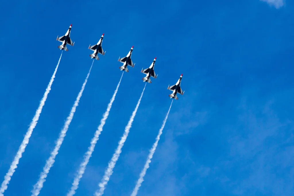 a group of fighter jets flying through a blue sky