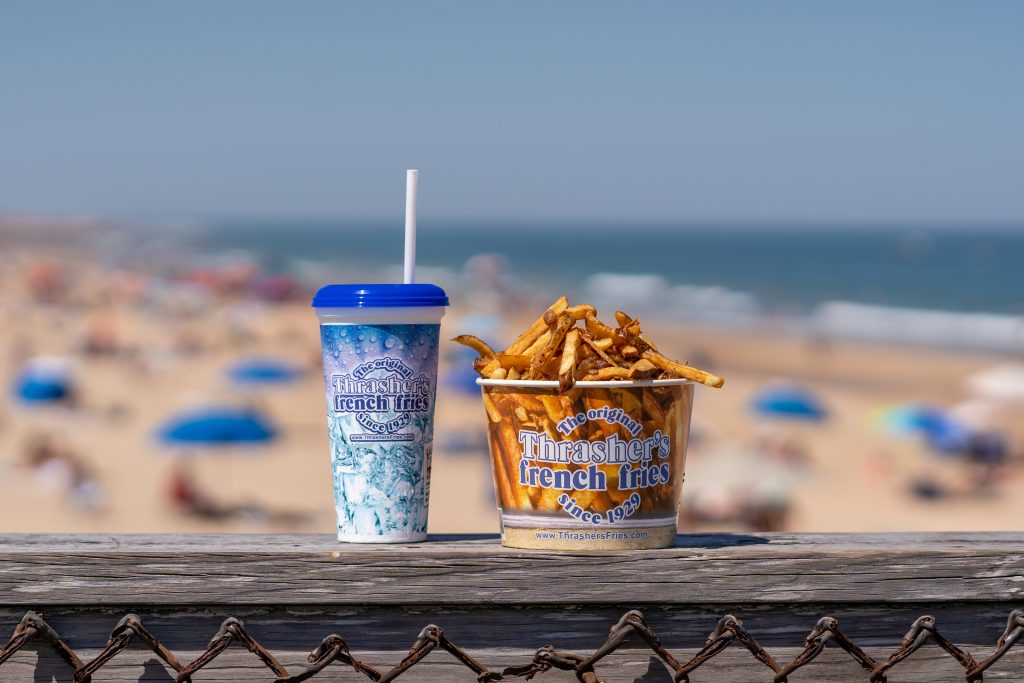 a cup of french fries and a drink on a wooden table