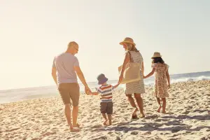 a family walking on the beach holding hands