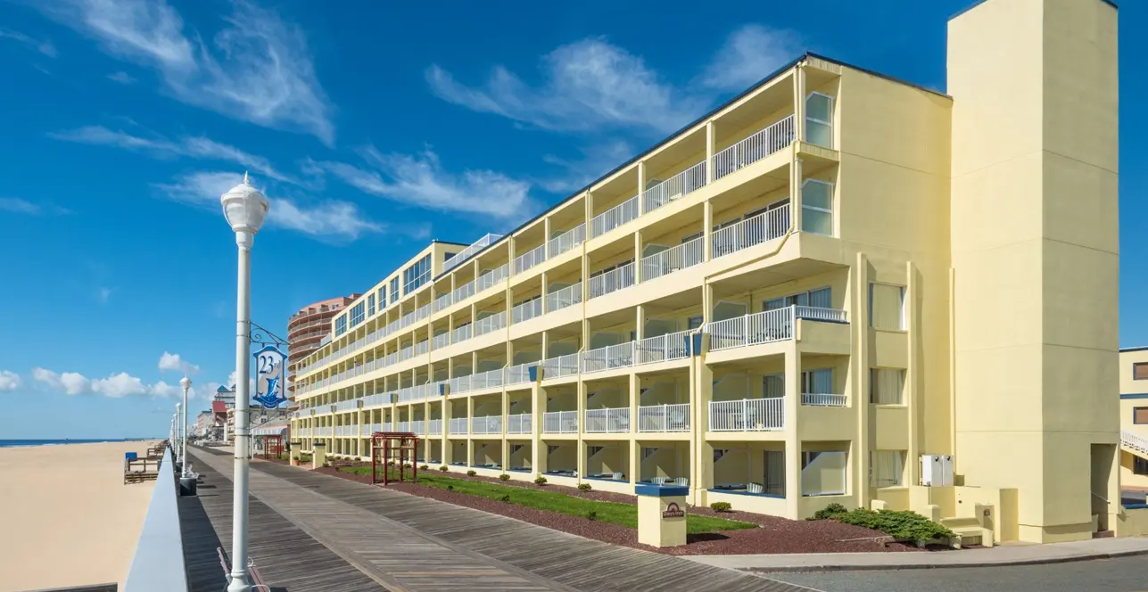 a large yellow building on the beach next to the ocean