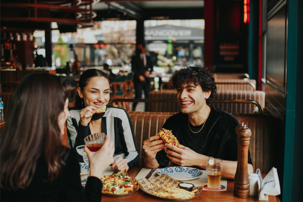 a group of people sitting at a table eating food