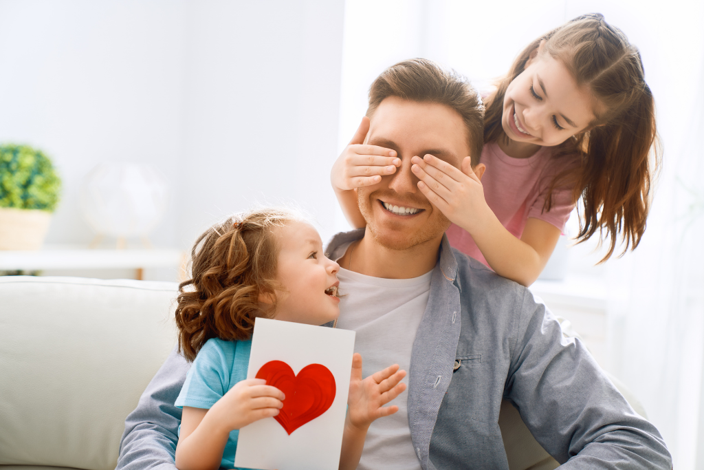 a man sitting on a couch with two little girls