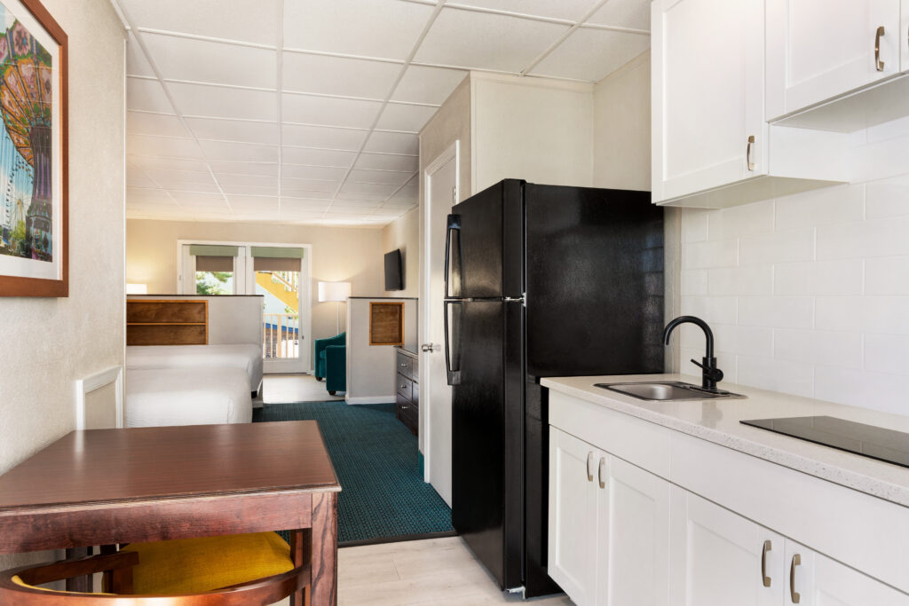a kitchen with white cabinets and a black refrigerator