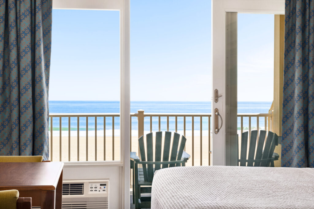a hotel room with a bed, chair, and a balcony