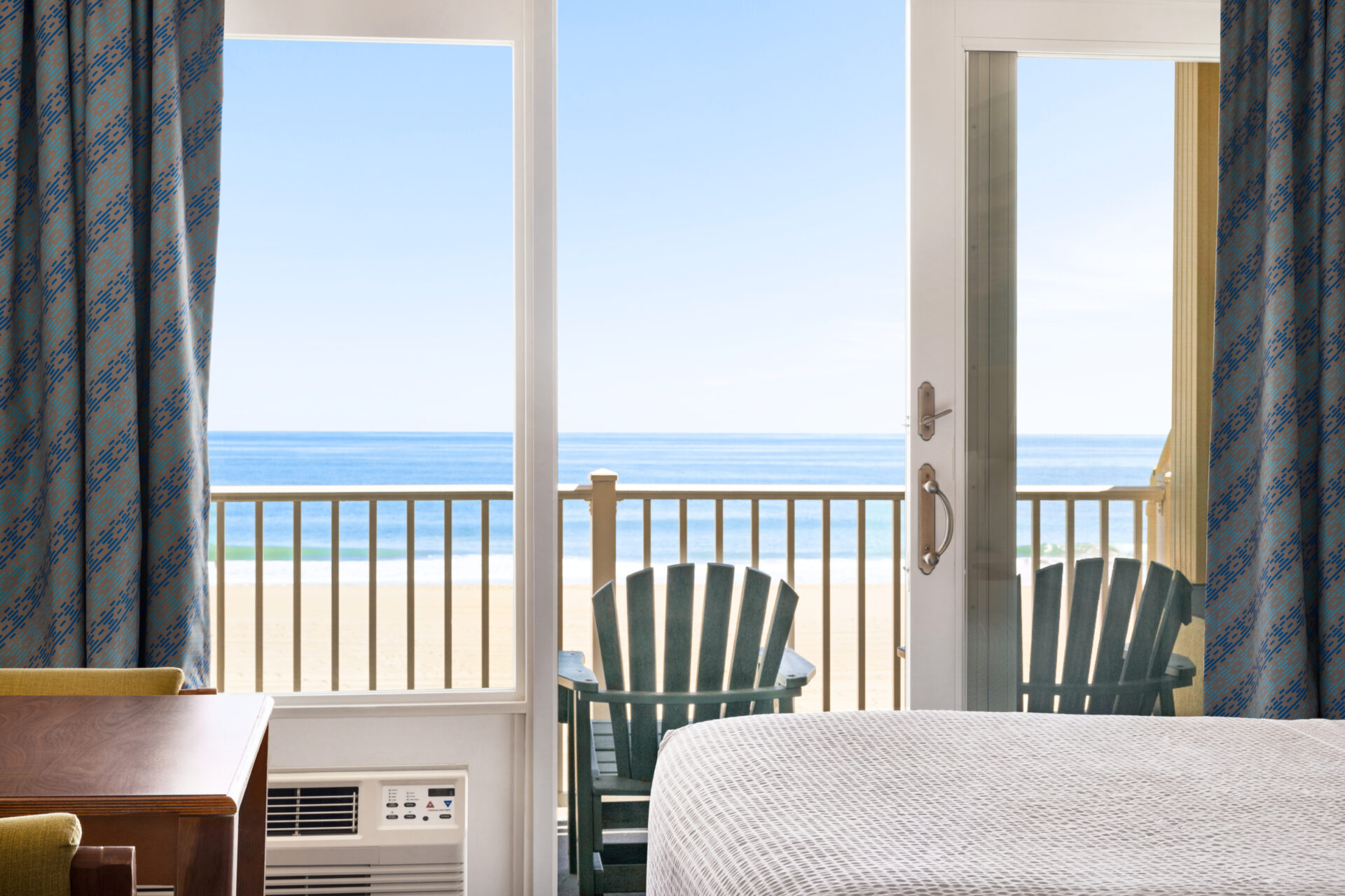 a hotel room with a bed, chair, and a balcony
